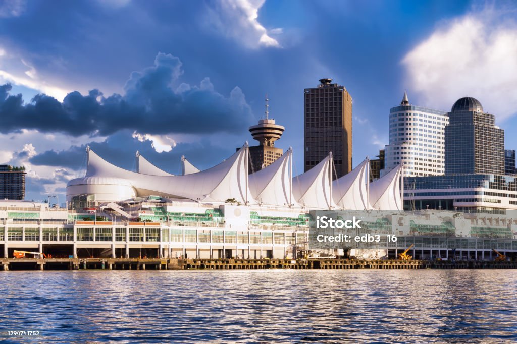 Downtown Vancouver, BC, Canada. Canada Place and commercial buildings in Downtown Vancouver Viewed from water. Modern Architecture in Urban City on West Coast of British Columbia, Canada. Sunset Sky Art Render Vancouver - Canada Stock Photo