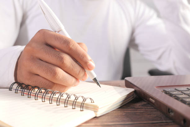 istock Close up of man hand writing on notepad. 1294742128