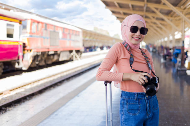 Female Islamic tourists hold cameras while waiting to travel. Female Islamic tourists hold cameras while waiting to travel. muslim photographer stock pictures, royalty-free photos & images