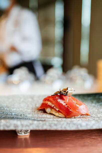 repas japonais omakase : le sushi au thon akami cru vieilli s’ajoute à la truffe tranchée servie à la main sur une assiette en pierre. repas traditionnel et de luxe japonais. - sushi styles photos et images de collection