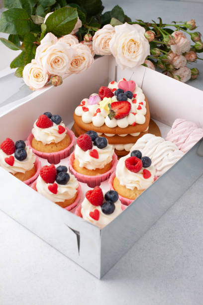 istock Preparing care package, seasonal gift box with cape cake and roses. Personalized eco friendly basket for holidays. Concept valentine day. Top view, flat lay 1294750280