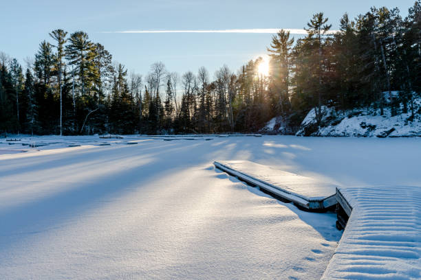 Sun burst in pine trees on a snowy northern Minnesota lake during a winter sunset