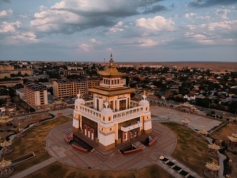 Arerial view Buddhist complex Golden Abode of Buddha Shakyamuni in Kalmykia (Great Hurul). Elista, Russia - July, 19 2020. The Great Hurul on the sunset and sky background. Pandemic. Closed to guests