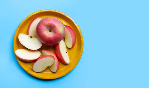 istock Ripe apple on plate on blue background. 1294768409
