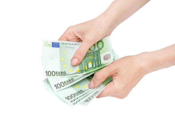 istock Woman's hands holding one hundred euro banknotes. Isolated on white. 1294777098