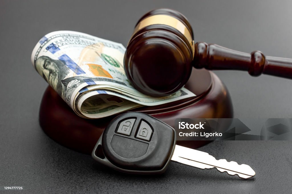Judge's gavel with car key and money on black. Car Accident Stock Photo