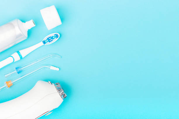istock Toothpaste, toothbrush and dental irrigator on blue background with copy space. 1294778170
