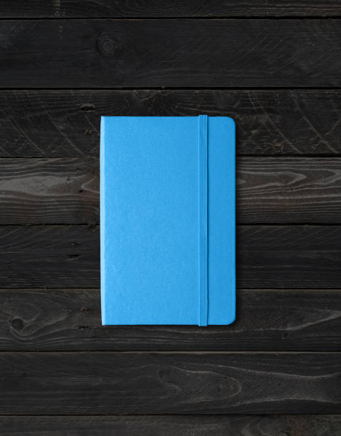 istock Blue closed notebook on black wood background 1294783819
