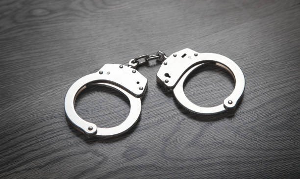 istock Metal handcuffs on the dark background. 1294785593