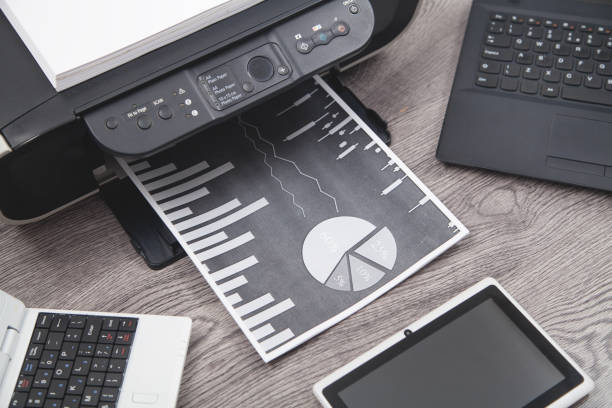istock Analyzing investment charts with printer and laptop. 1294785605