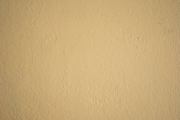 istock A well-done light yellow wall texture background. Painted cement wall backdrop. 1294787803