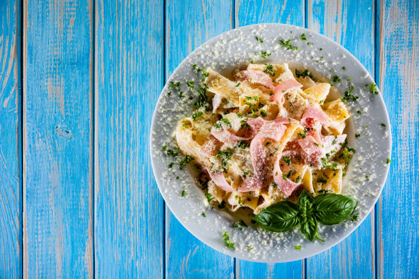 Pasta carbonara - tagliatelle with cream sauce and ham on wooden table