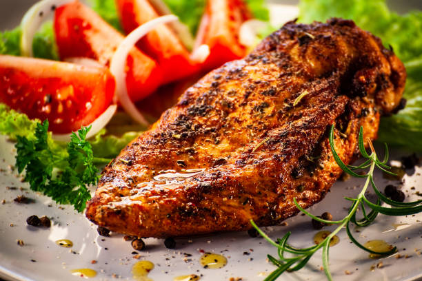 istock Fried chicken breast and fresh vegetables on wooden table 1294793373