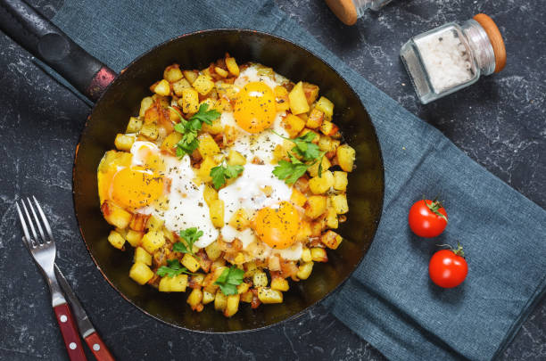 istock Potato hash with eggs and herbs for breakfast on black stone background 1294794020