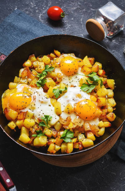istock Potato hash with eggs and herbs for breakfast on black stone background 1294795007