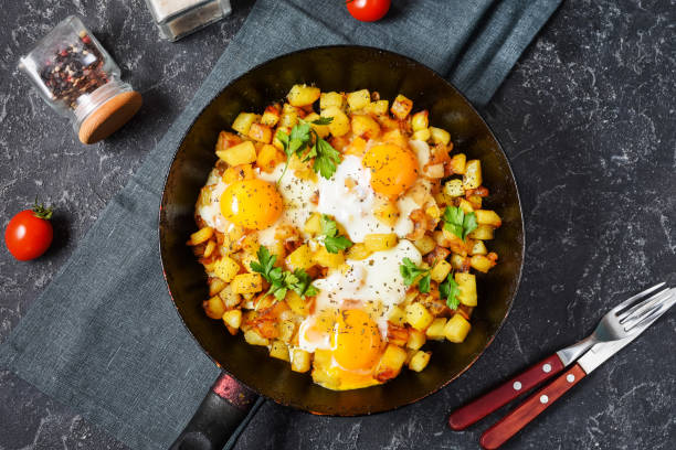 istock Potato hash with eggs and herbs for breakfast on black stone background 1294795211