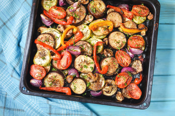 istock Roasted vegetables mix on baking tray on blue wooden background 1294795324