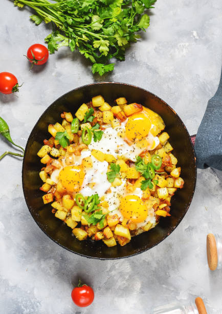 istock Potato hash with eggs and herbs for breakfast on concrete background 1294796876