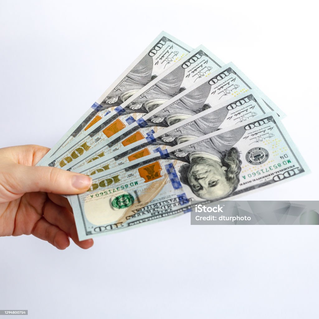 Hundred dollars banknote in hand, cash money to spend right now. Hundred dollars banknote in hand, cash money to spend right now. The economic crisis as a consequence of quarantine. Government help. Cashier Stock Photo