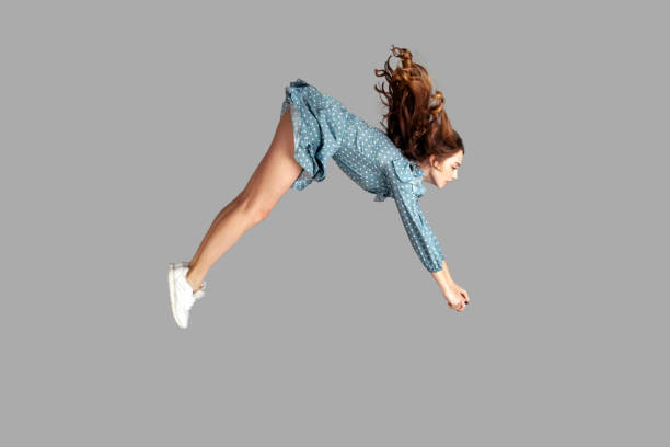 istock Side view girl rushing at full speed accelerate, steering driving fast and levitating in air. Model flying rapidly 1294804739