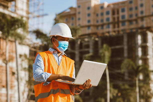 istock Engineer construction wearing protective mask the spread of Covid 19 diseases during the inspection in construction site with computer laptop. Safety concept 1294806938