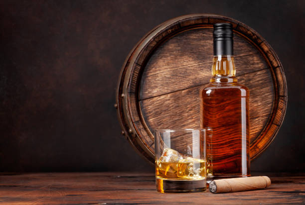 scotch whiskey bottle, glass, cigar and old barrel - cigar whisky bar cognac imagens e fotografias de stock