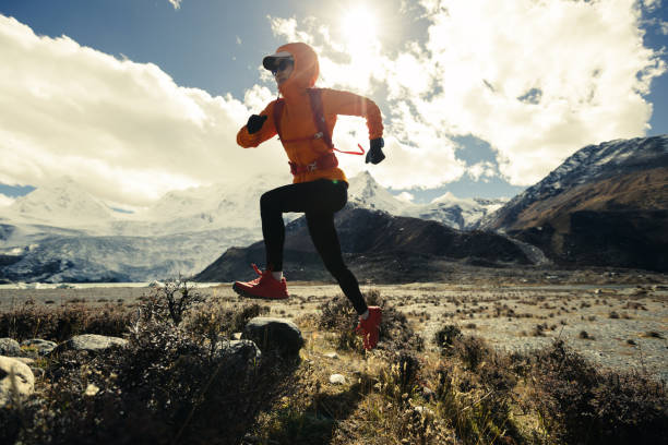 mulher trail runner cross country correndo em alta altitude natureza inverno - exploration mountain ice jumping - fotografias e filmes do acervo