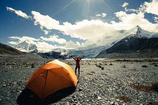 Cheering woman hiker enjoy the beautiful landscape in tent