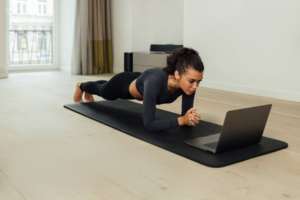 istock Young fit woman doing plank on mat at home 1294815698