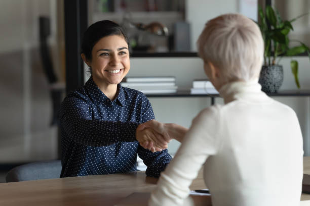 istock Rear view hr manager shaking Indian candidate hand at meeting 1294818739