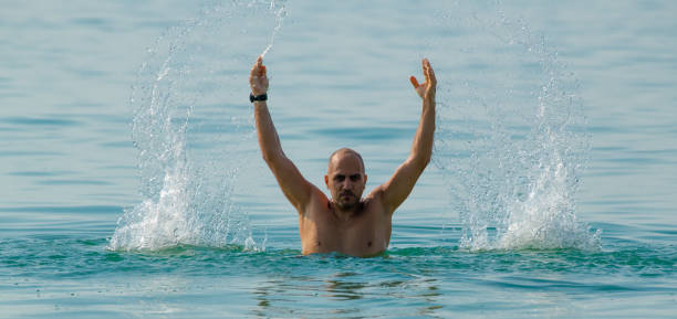 istock man splashing water in the sea 1294819632