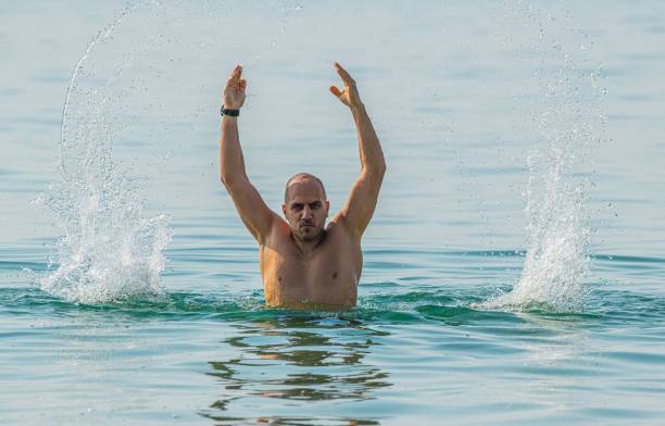 istock man splashing water in the sea 1294819646
