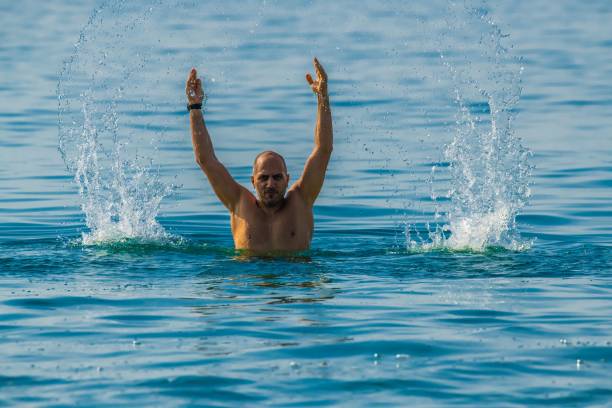 istock man splashing water in the sea 1294819651