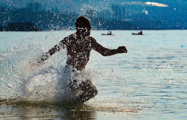 man at a beach running into the sea water