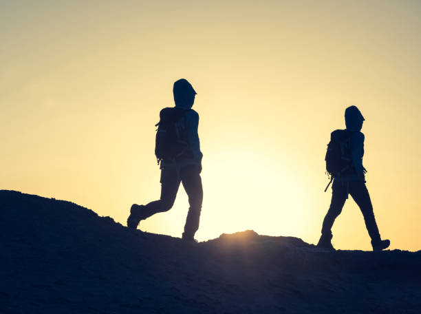 istock Hiking on sunset desert, multiple exposure of backpacker walking in desert 1294821454