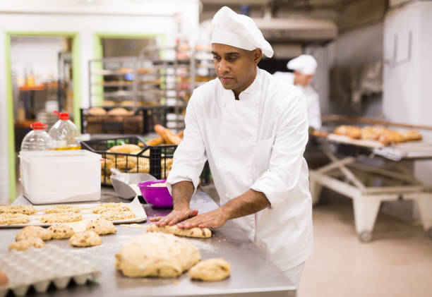 istock male baker in white uniform rolling out dough in kitchen 1294825878
