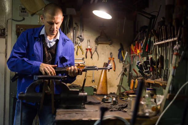 istock Skilled craftsman of weapons workshop disassembling AK assault rifle 1294826039
