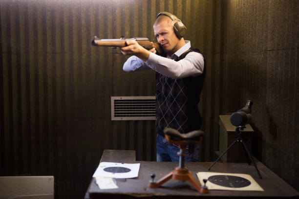 istock Focused man aiming shotgun at target in shooting range 1294826076