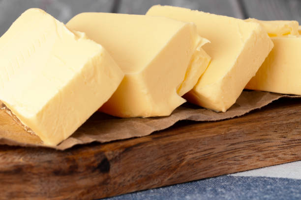 istock Wooden board with butter on blue checkered napkin 1294831411