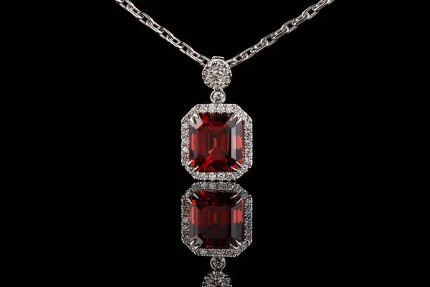 beautiful gold pendant with gemstones garnet and diamonds on a black background close-up