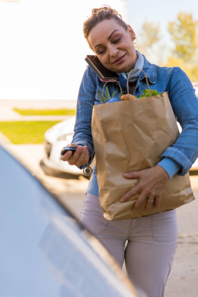 istock Talking over the phone, carrying groceries and unlocking the car 1294834836