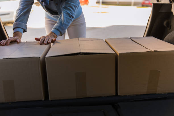 istock Arranging boxes for delivery in a car trunk 1294835632
