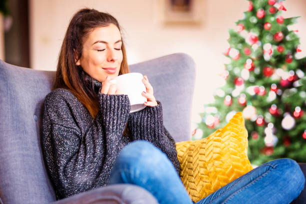 istock Smiling woman relaxing at home during christmas time 1294836324