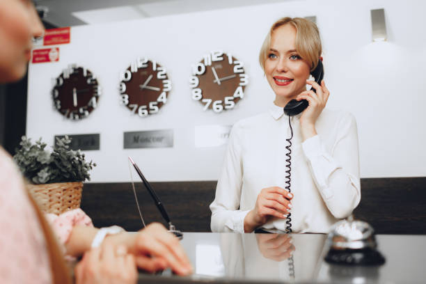 istock Female receptionist in hotel talking on the phone at work 1294852240