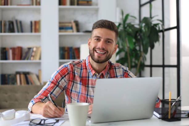 istock Happy young business man is analizing financial documents from home during self isolation. 1294852338