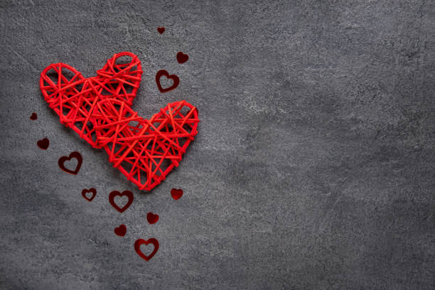 istock Two red hearts on a gray concrete background. Valentine's day concept. Copy space. View from above. 1294853712