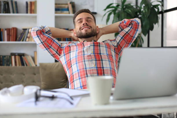 istock Smiling handsome businessman relaxing at home office. 1294854130