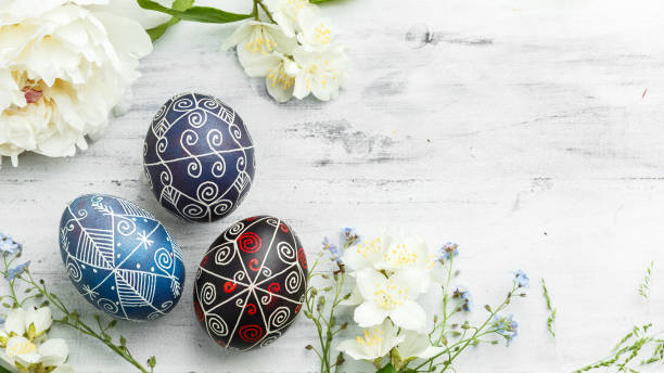 Pysanky Ukrainian Easter Eggs on shabby background Three handmade painted Easter eggs with spring flowers. Ukrainian pysanka decorated with wax-resist dyeing technique on white shabby wooden background with empty space for text orthodox church easter stock pictures, royalty-free photos & images