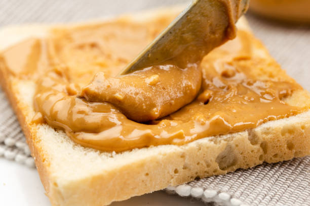istock Crunchy peanut butter spreading on a toast 1294861376