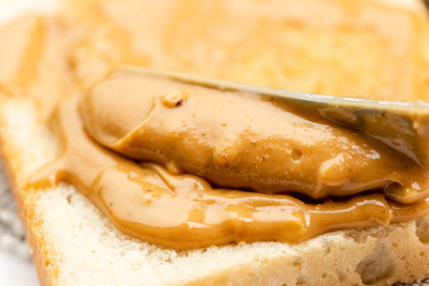 istock Crunchy peanut butter spreading on a toast 1294861378